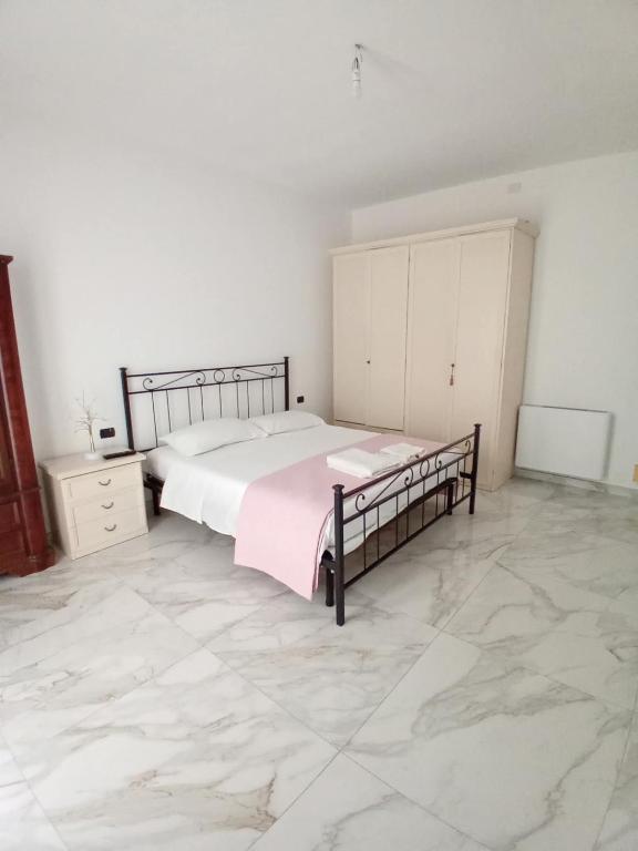 a bedroom with a large bed and a tiled floor at Valentina GuestHouse in Sestu