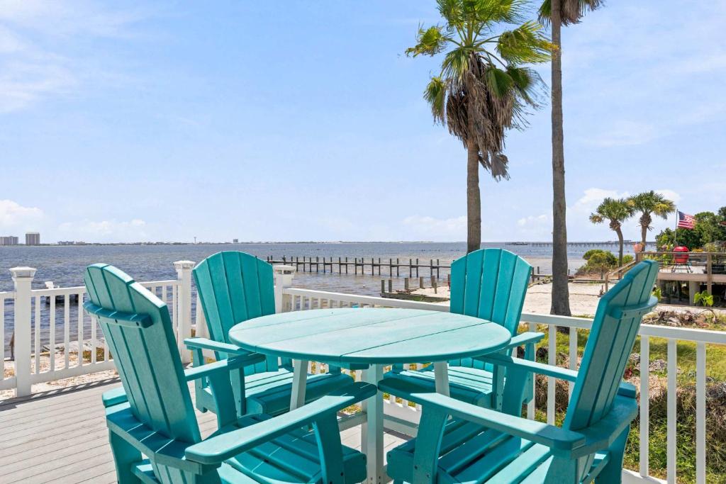 a table and chairs on a deck with the beach at Waterfront Views & Beach Access - pet friendly in Navarre
