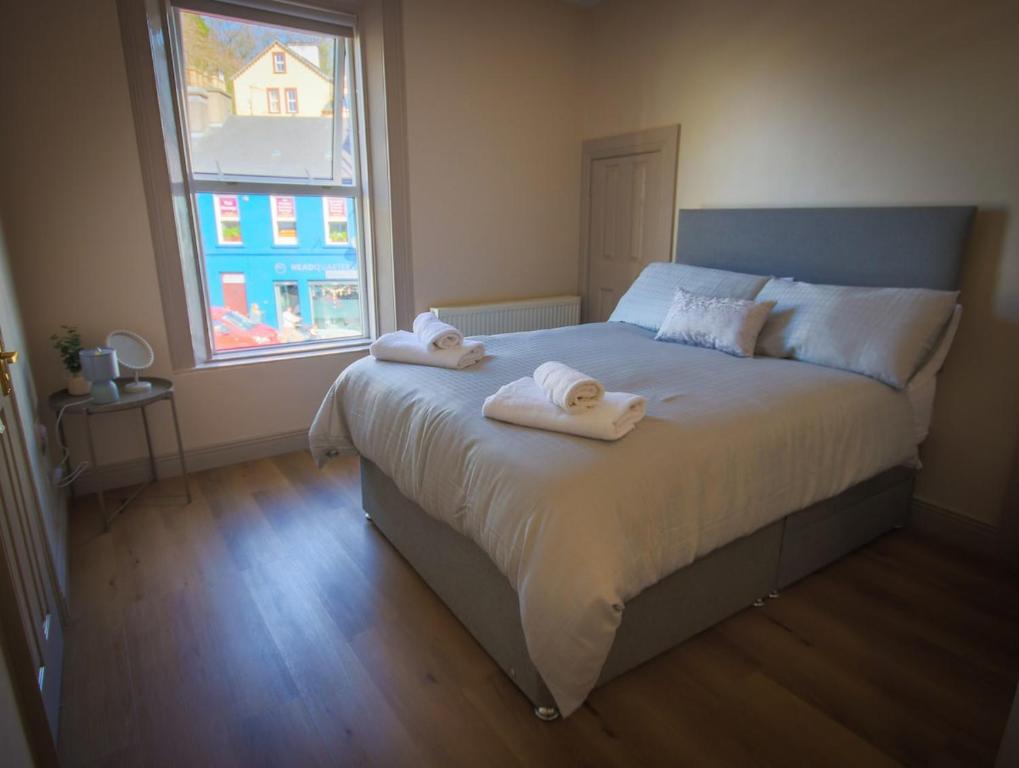 a bedroom with a large bed with towels on it at East Bridge House in Enniskillen