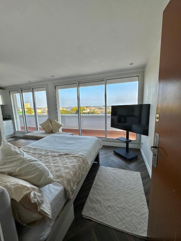 a bedroom with two beds and a flat screen tv at Chez Lima in Lorient