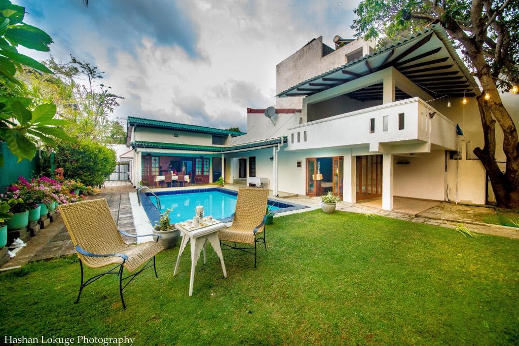 a backyard with a table and chairs and a pool at serendipty lake villa in Panadura