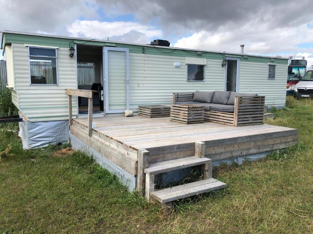 a wooden deck with a couch on a trailer at Arrie in in Vellinge