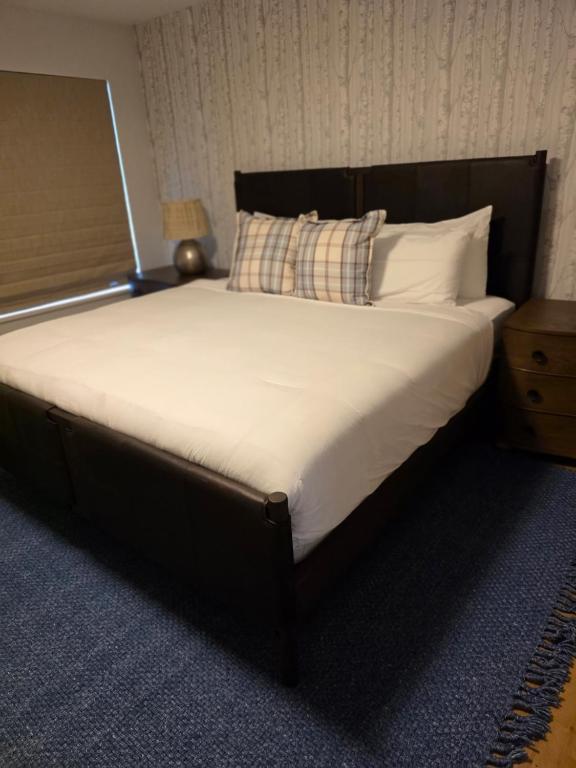 a large bed with white sheets and pillows in a room at Telluride Creekside Condo 3 Min to Chair 7 in Telluride