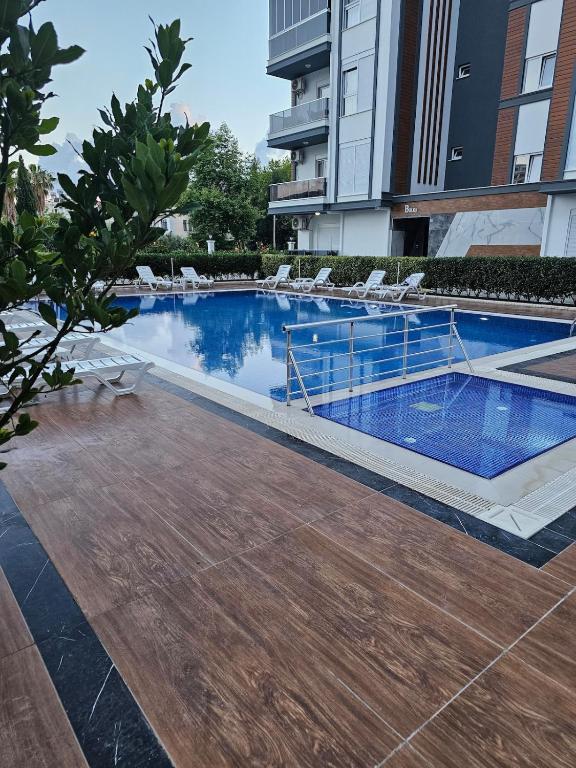 a swimming pool in a building with chairs around it at Daire 1 in Gazipasa