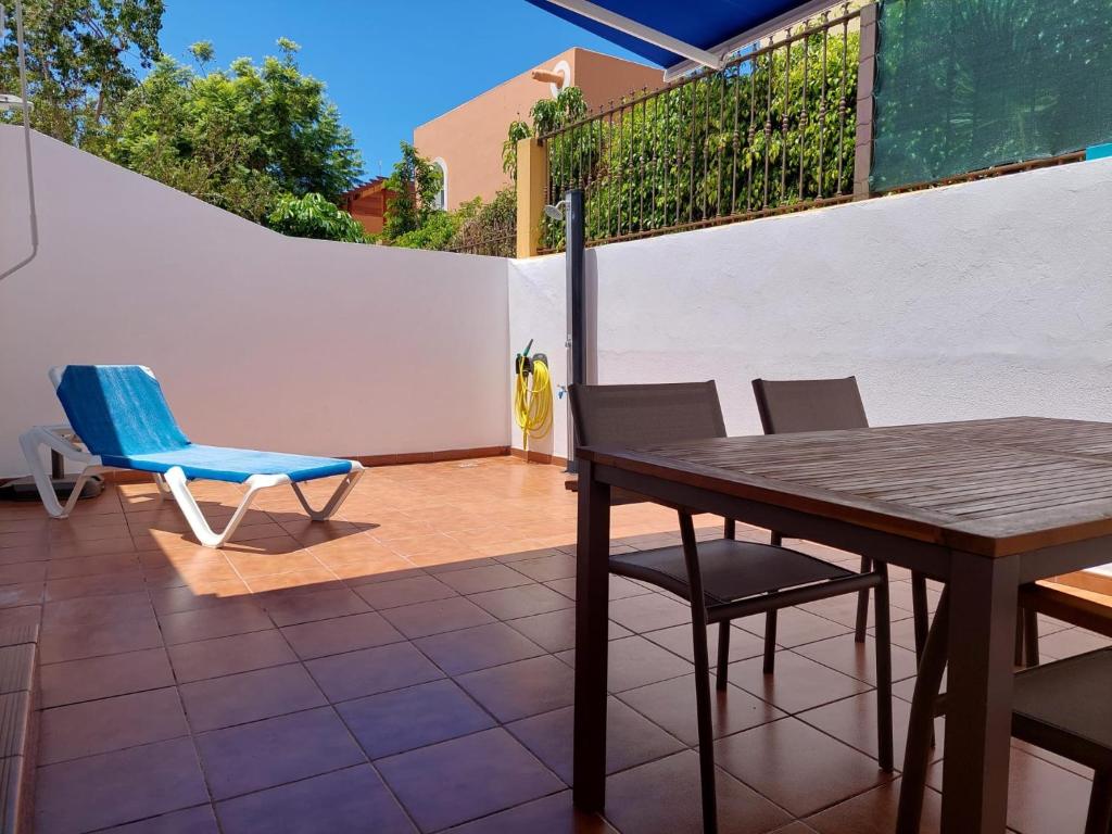 a patio with a wooden table and chairs at Playa de Mogán in Playa del Cura