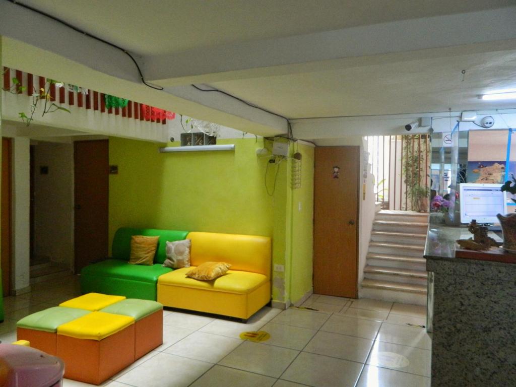 a living room with a yellow and green couch at Casa Laurel in Cancún