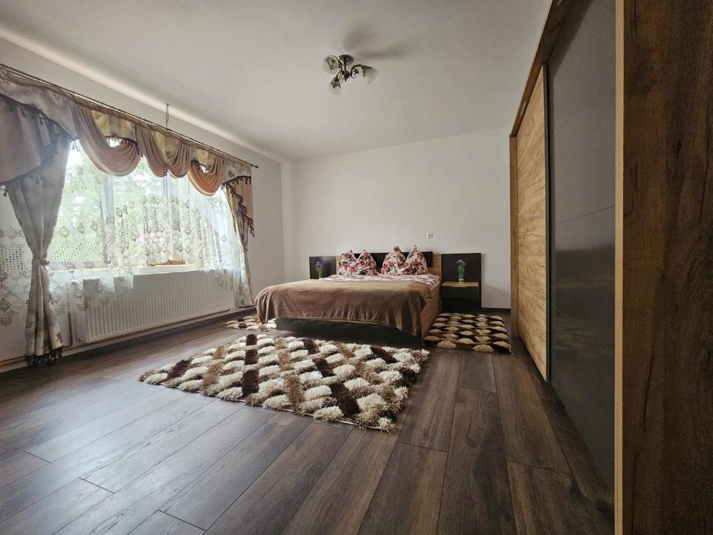 a bedroom with a bed and a large window at casa TURNU RUIENI in Turnu Rueni
