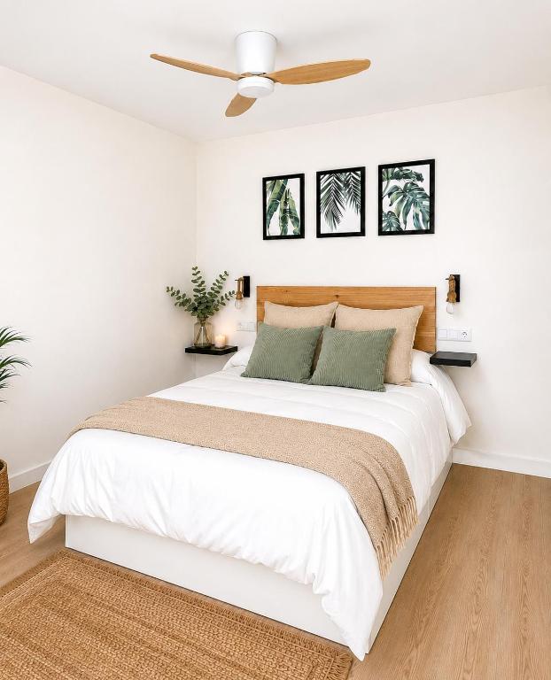 a bedroom with a white bed with a ceiling fan at Apartamento Premium Ávila PLAZA MAYOR con PARKING in Ávila