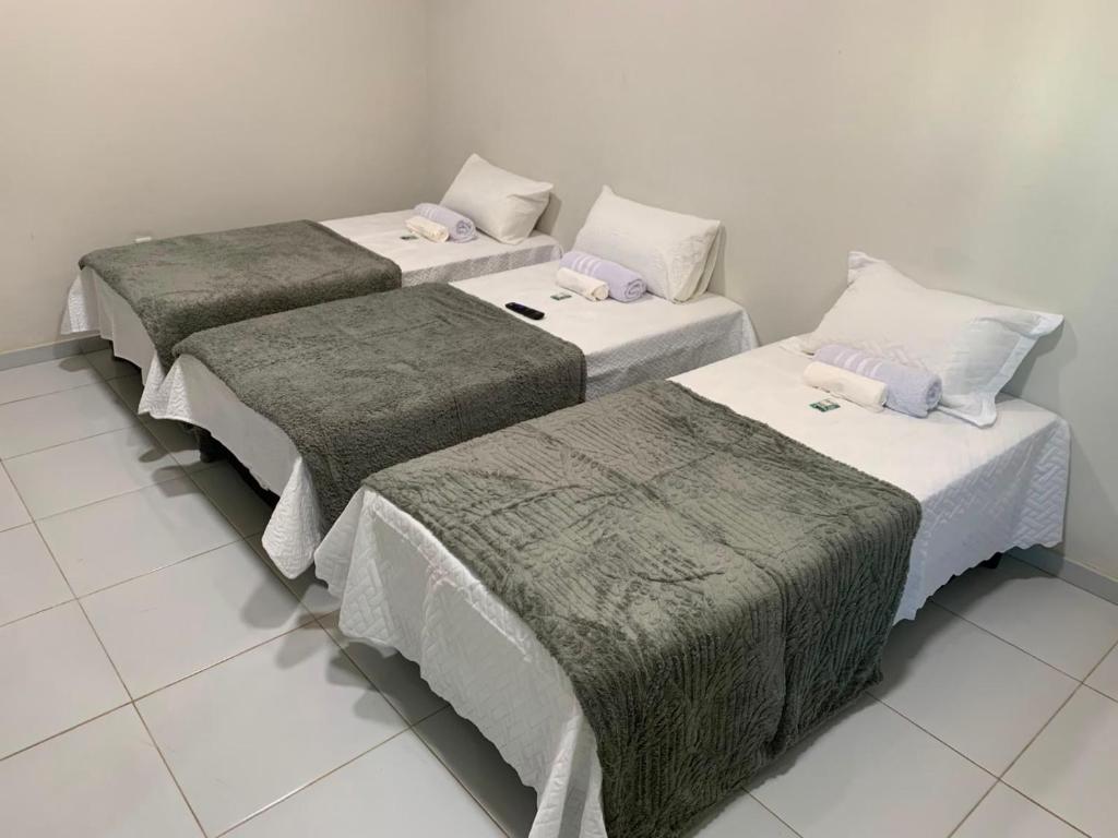 a group of three beds in a room at Pousada Brisa dos Mares Macaé in Macaé