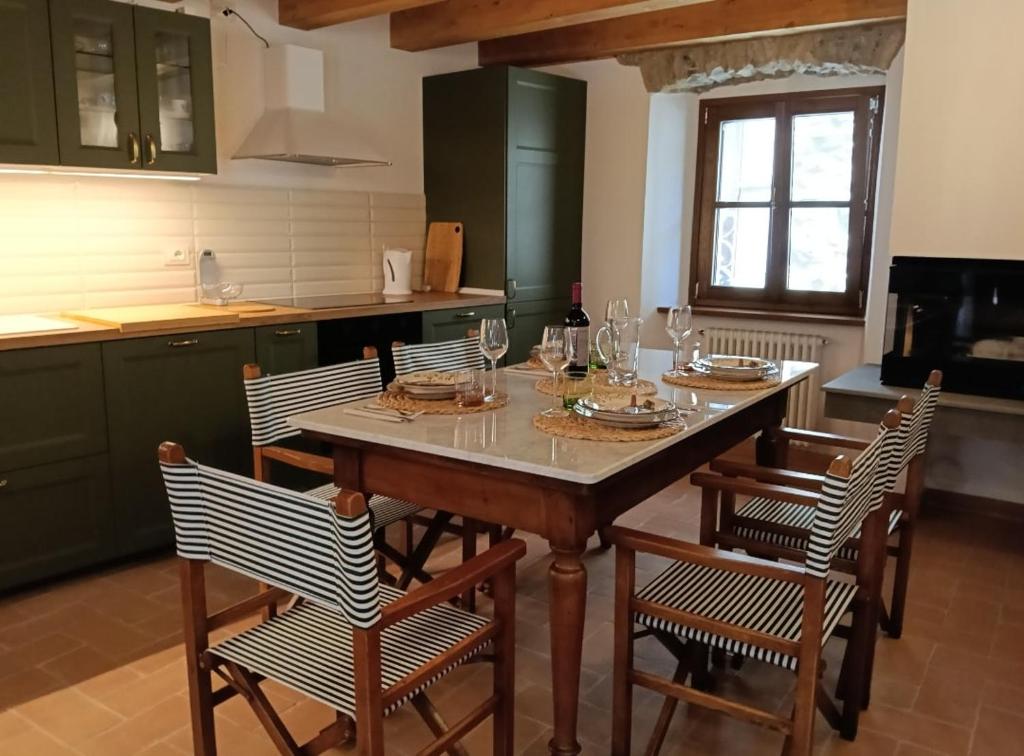 a kitchen with a table with chairs and wine glasses at Casa Il Borgo 1 in Tavernelle