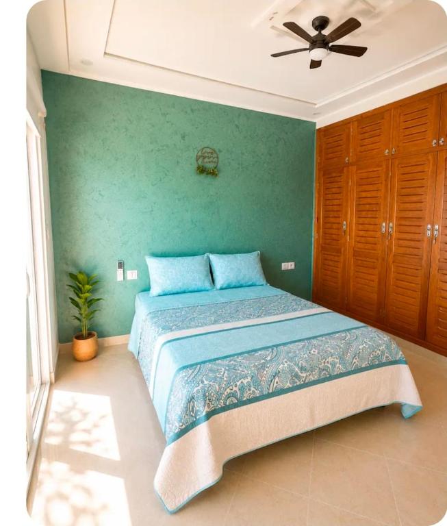 a bedroom with a bed and a green wall at appartement in Oujda