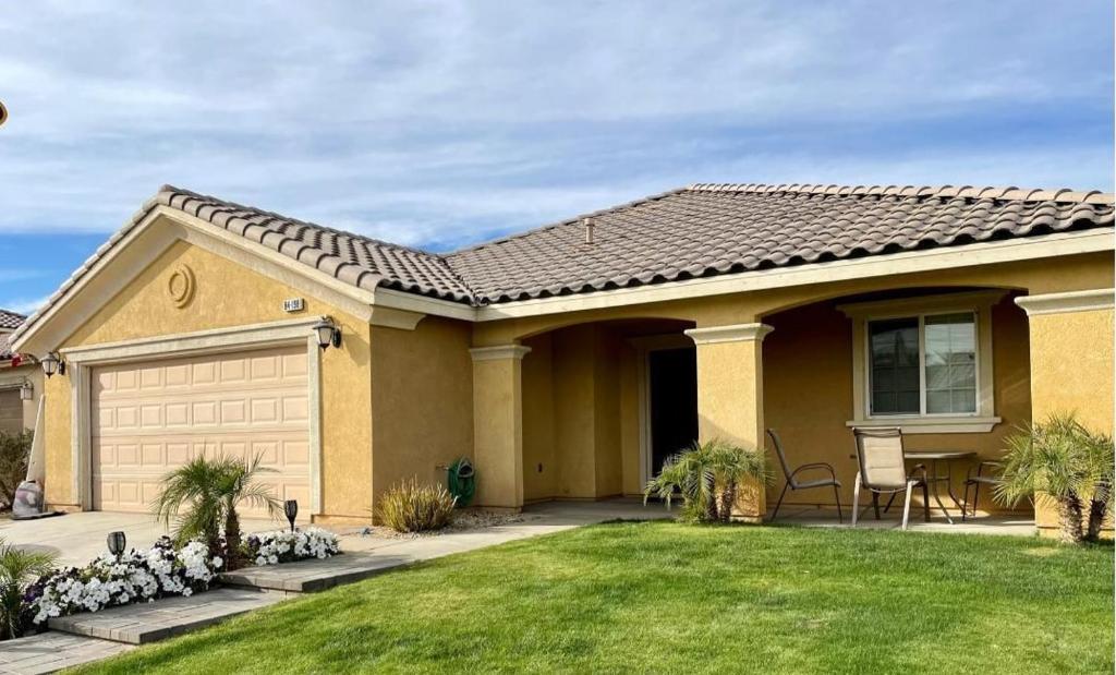 a house with a garage and a grass yard at Family 4BR Home with Spacious Backyard in Coachella
