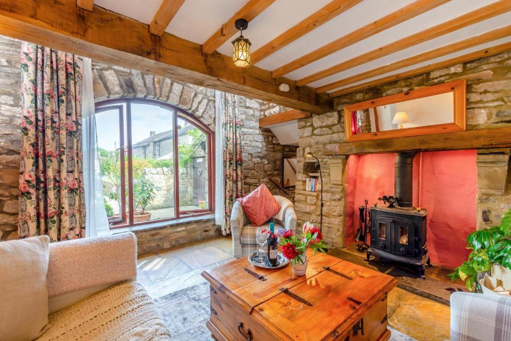 a living room with a fireplace and a wooden table at 1 Bed in Richmond oc-44401 in Reeth