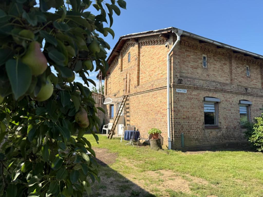 an old brick building with two chairs in a yard at Landhaus Settin 