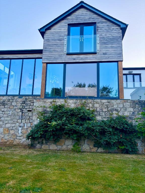a house with windows on top of a stone wall at Mincarlo House in St Austell