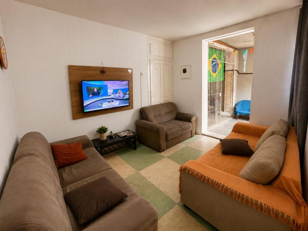 a living room with a couch and a tv at Casa Art Maison Recife in Recife