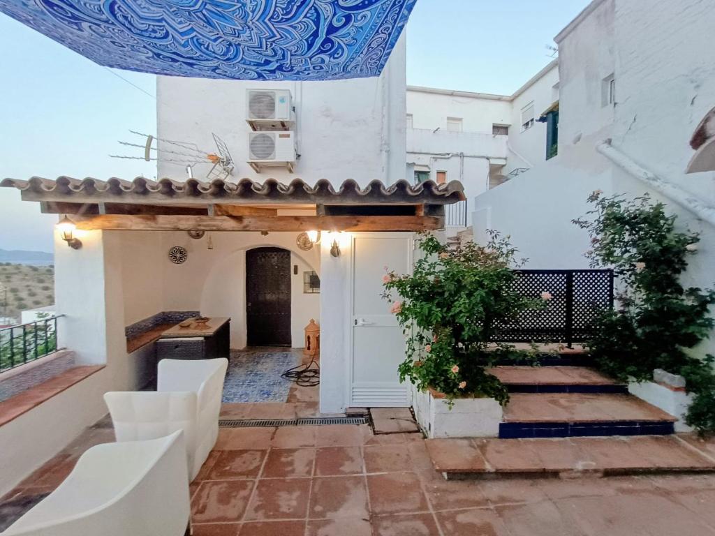 a courtyard in a house with a door and chairs at Ideal Perros Patio Privado Casa Jaruf in Arcos de la Frontera