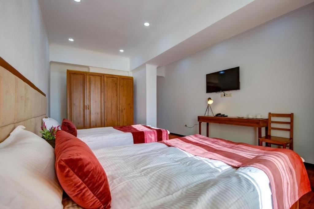 a bedroom with two beds with red pillows at Gold ASSN in Cholpon-Ata