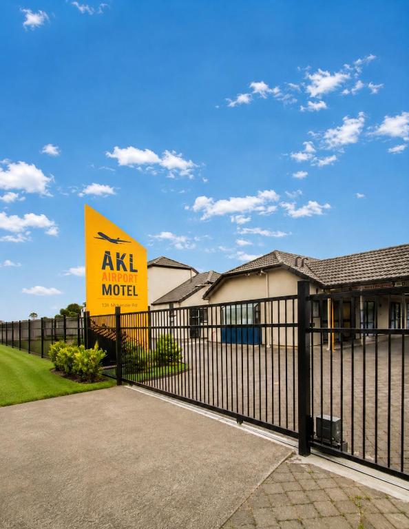 a sign on a fence in front of a ask model house at Auckland Airport Motel in Auckland