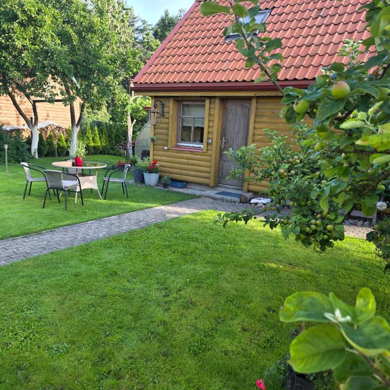 a small house with a table and chairs in a yard at Sauļuki in Ventspils