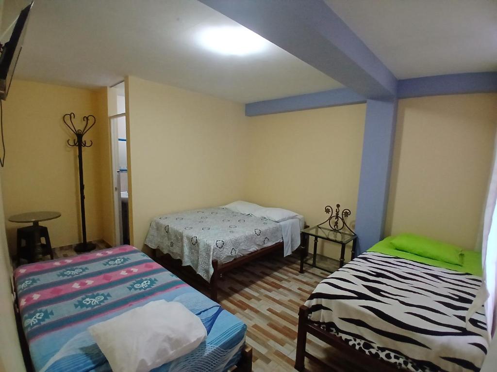a room with two beds in a room at Hospedaje Vicente in Lunahuaná