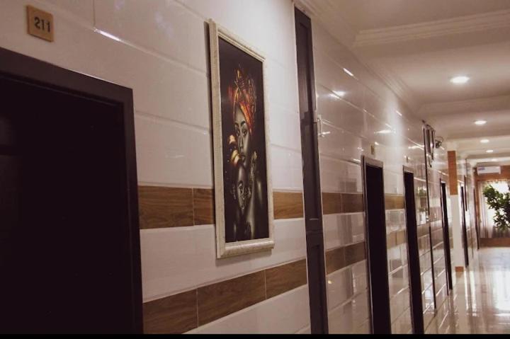 a hallway with a row of paintings on the wall at Koro Guess House in Lagos