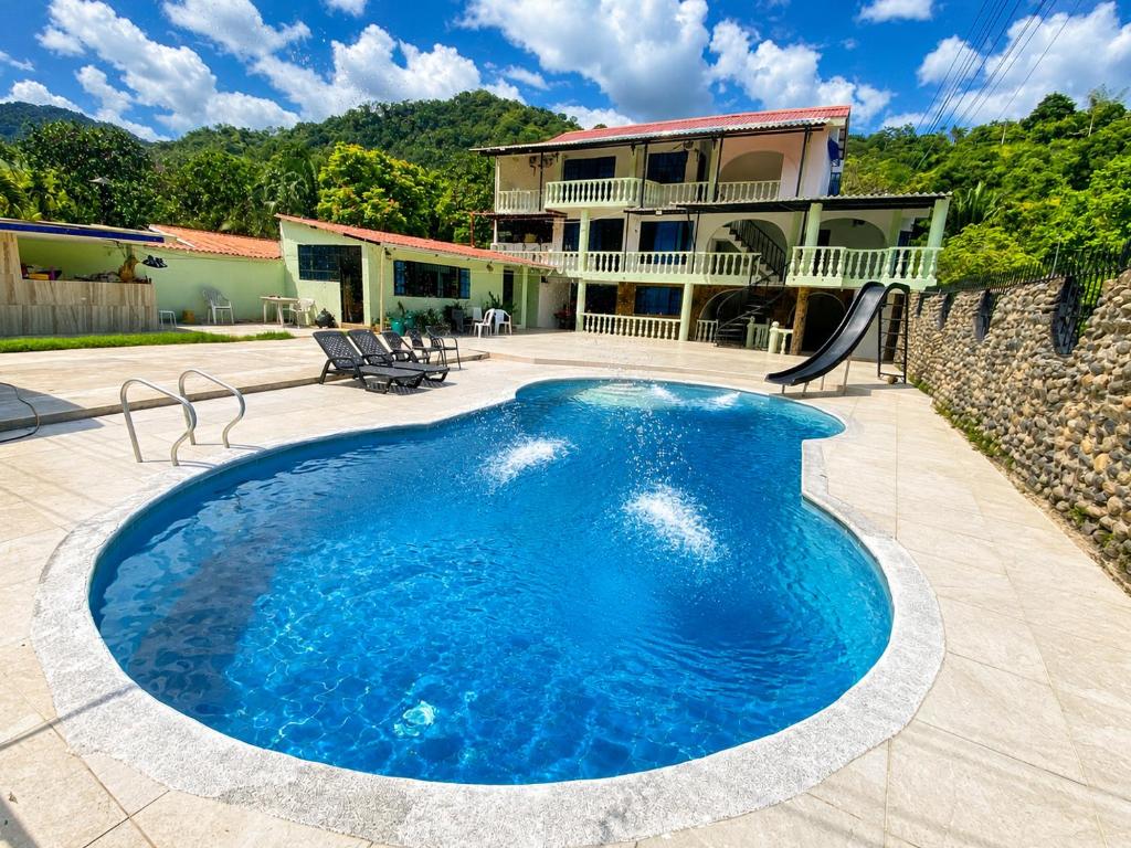 a swimming pool in front of a house at El Bosque in Nocaima