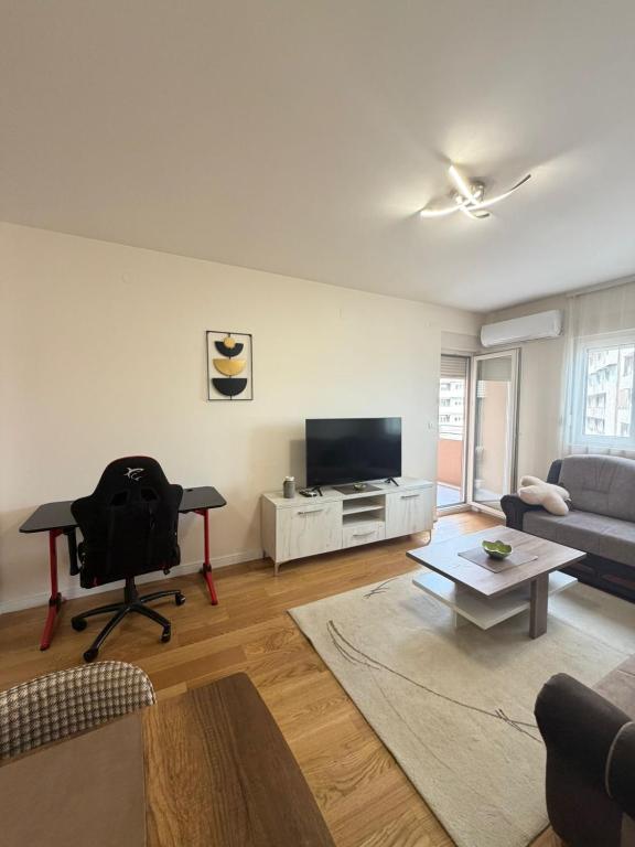 a living room with a couch and a television at Apartment Central Point - Podgorica in Podgorica