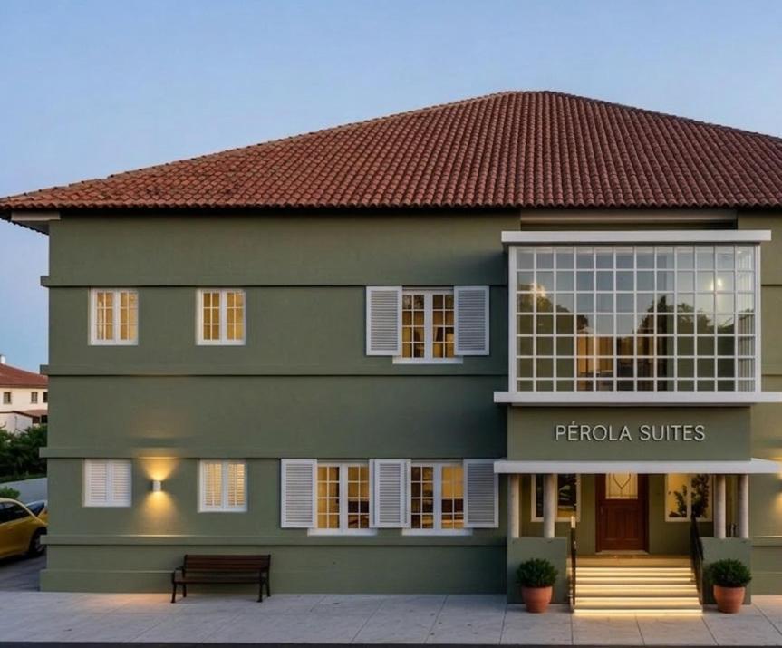 a green building with a sign in front of it at Pérola Suítes Boutique Hotel in Luanda