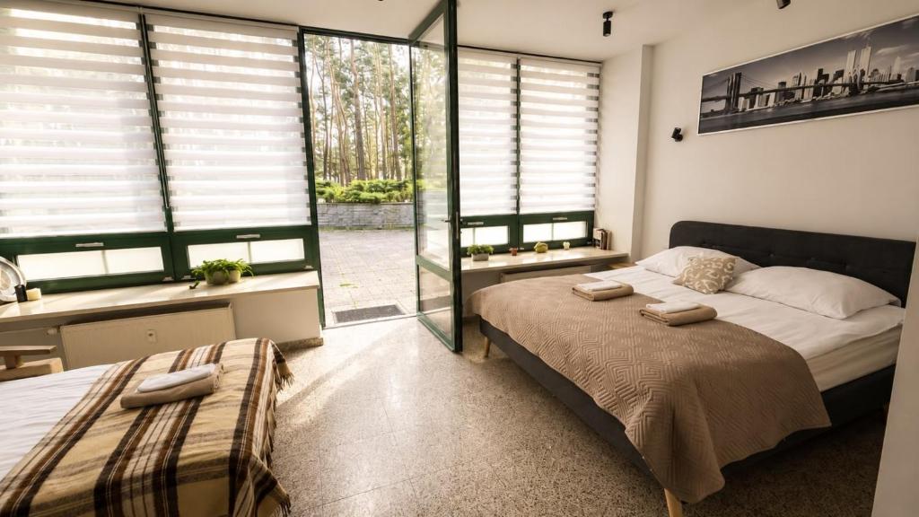 a bedroom with a large bed and a large window at Apartament w Sosnowym SPA in Serock