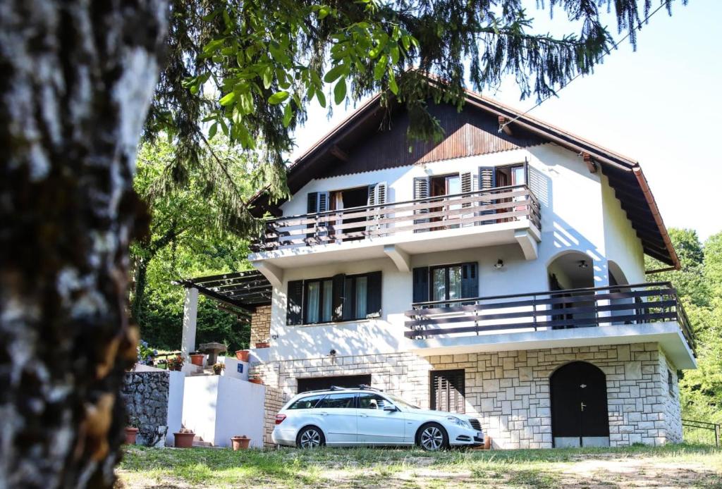 a white car parked in front of a house at Villa DORA in Vrbovsko