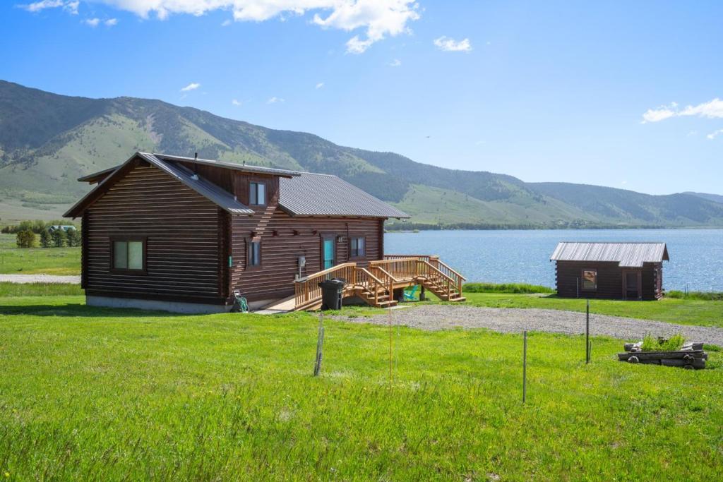 a log cabin and a house on the shore of a lake at Henry's Lake View Cabin + BBQ + Fire Pit + Decks! in Island Park