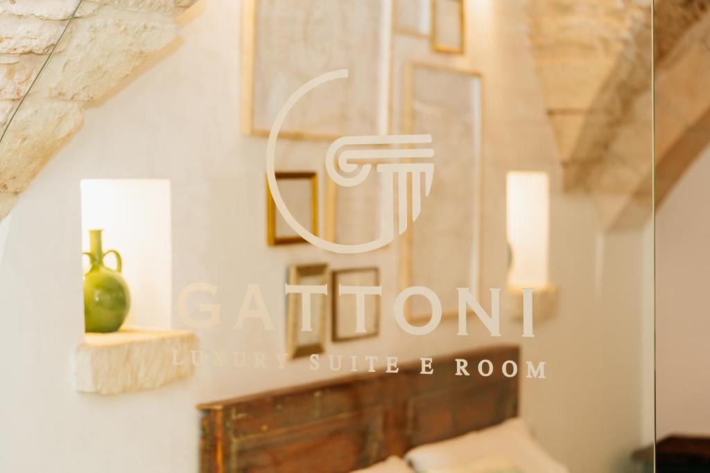 a logo for a white room with a picture on a wall at Gattoni Suite by Rentbeat in Martina Franca