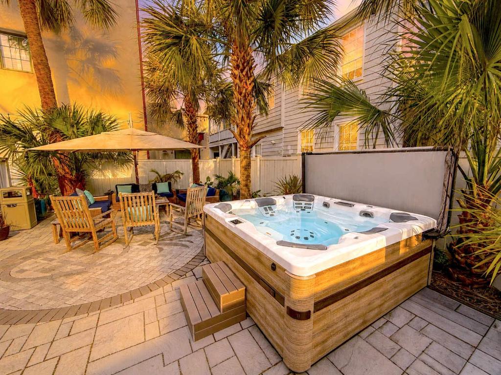 a hot tub in a patio with a table and chairs at Hidden Outdoor Oasis - 1 BLOCK TO KING in Charleston