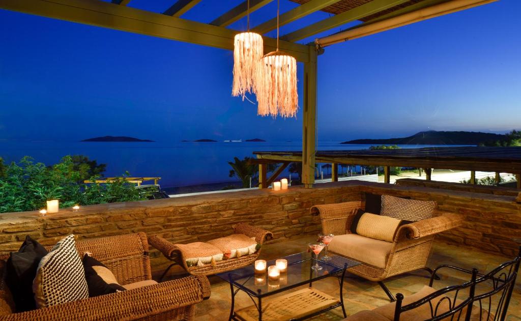 une terrasse avec des chaises et une table avec des bougies dans l'établissement Beachfront Pleasure, à Kypri