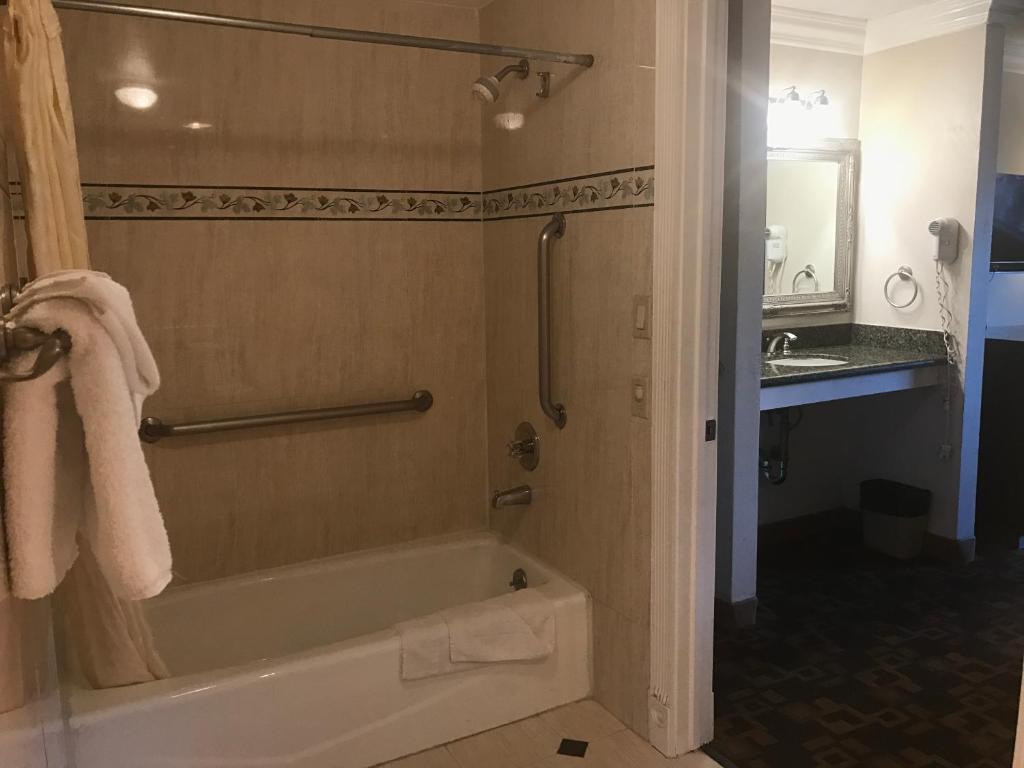 a bathroom with a bath tub and a sink at Castaic Inn Six Flags Valencia in Castaic