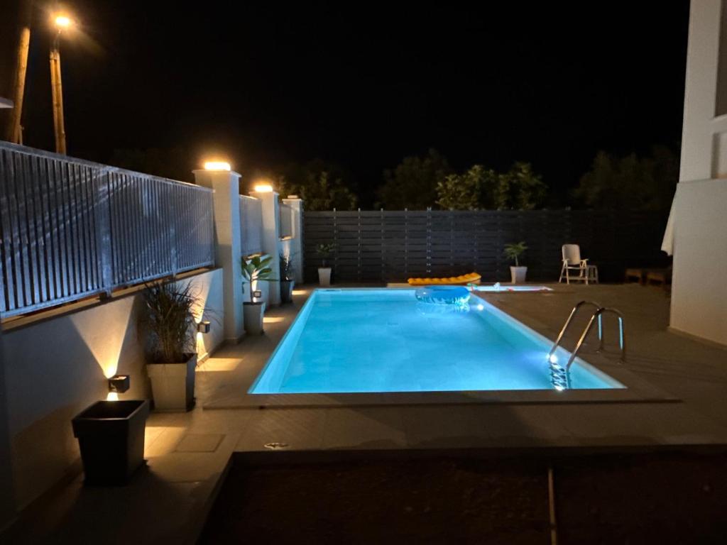 a swimming pool in a backyard at night at Exclusive Villa with Pool in Káto Ássos