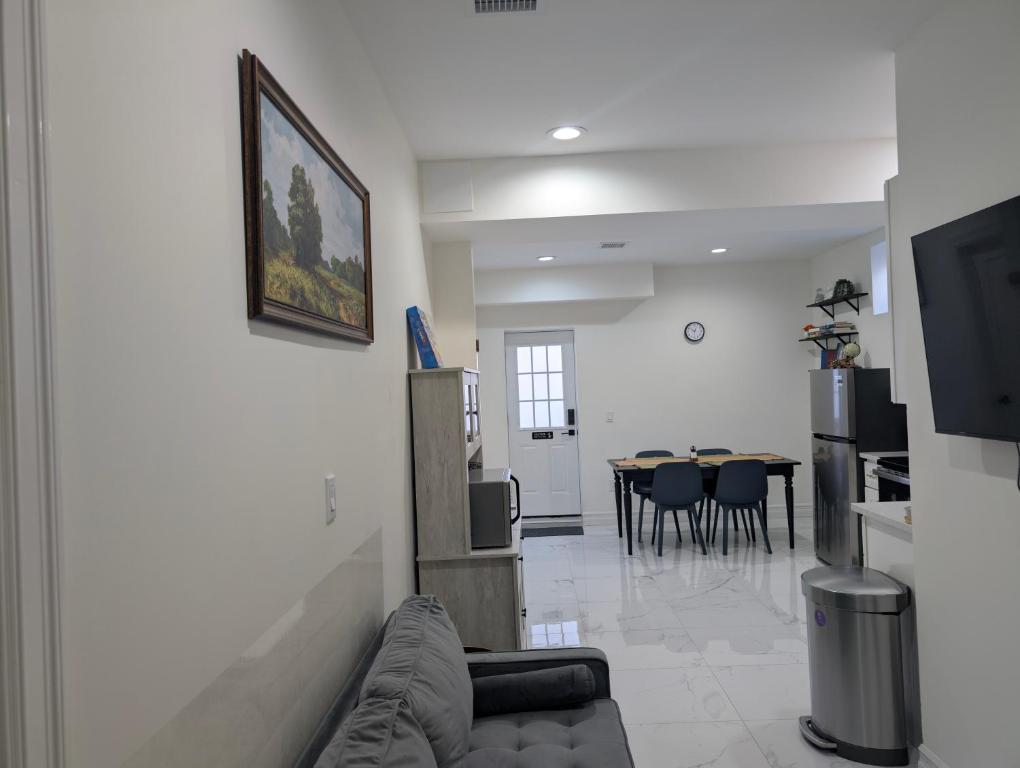 a living room with a couch and a dining room at Modern Comfort - Minimal Style in Elmont