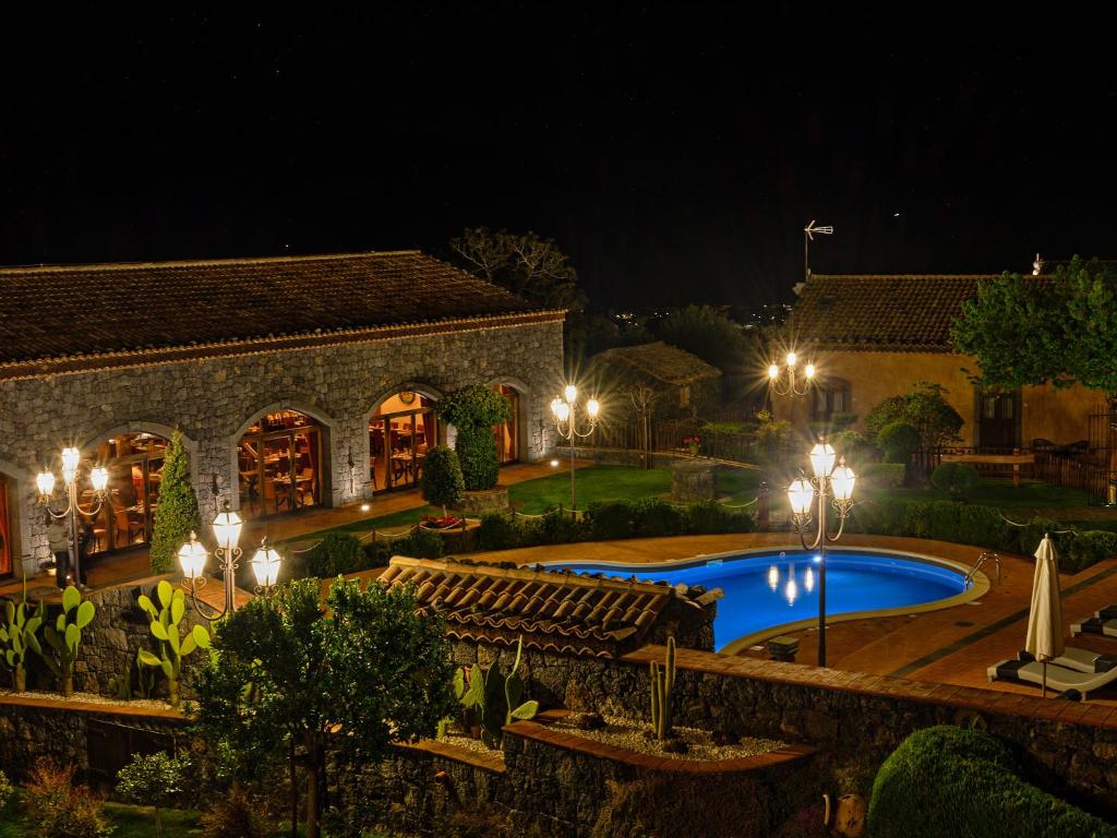 a house with a swimming pool at night at Etna Quota Mille Boutique Hotel, Typical Sicilian Food & Wine in Randazzo