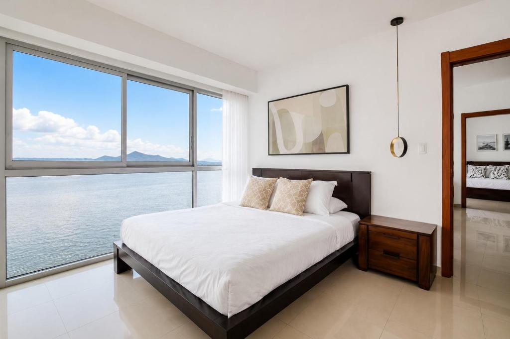 a bedroom with a large bed and large windows at THE VIEW AT RIVEFRONT by Bahama Rentals in Guayaquil