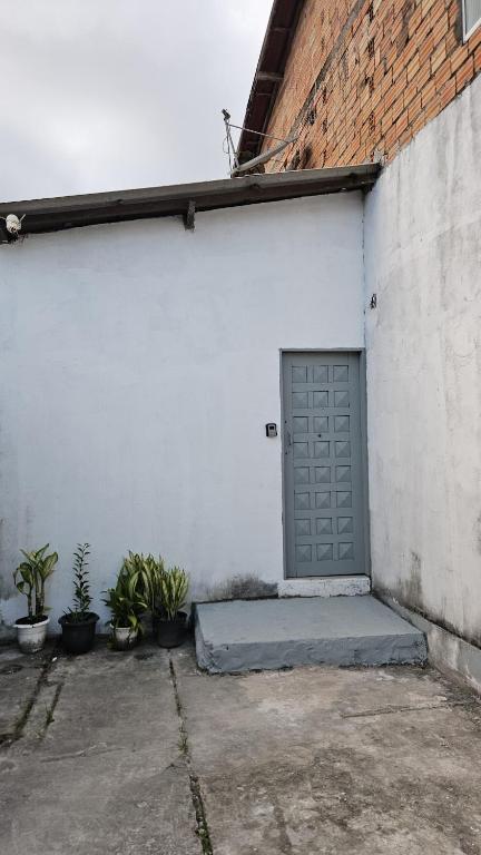 a white building with a door and some plants at Casa Vigia 1 Quarto in Vigia