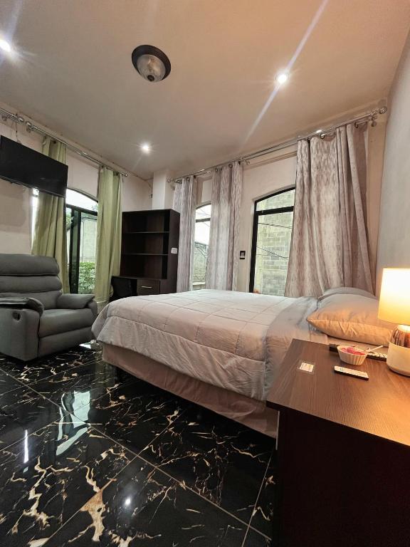 a bedroom with a bed and a desk and a couch at Casa Borde de lago2 in Panajachel