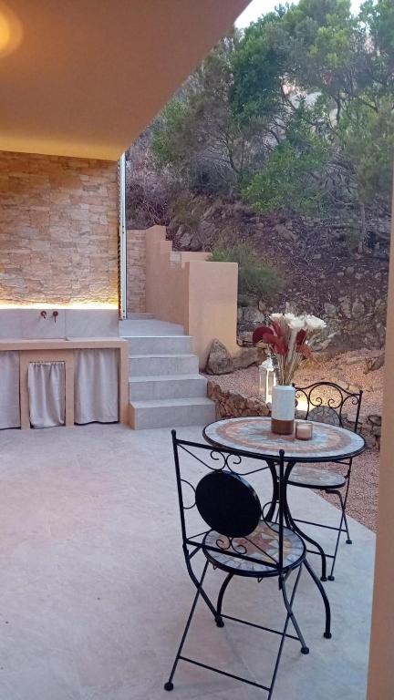 a patio with a table and chairs and stairs at Appartamento "Hic et Nunc" in Costa Paradiso