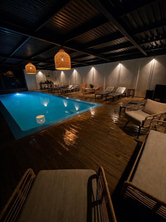 a swimming pool in a room with tables and chairs at forest house - Cabaña para 4 in Pichilemu