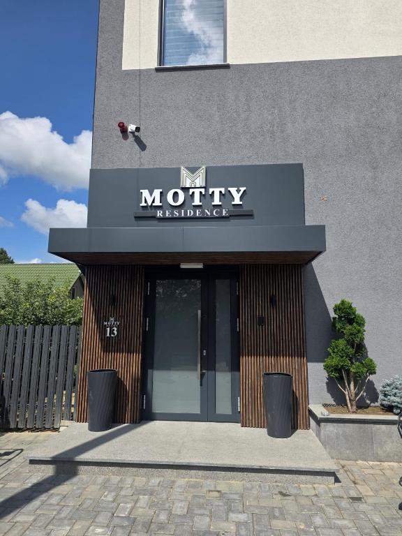 a motel entrance with a sign on a building at Motty Residence in Vicovu de Sus