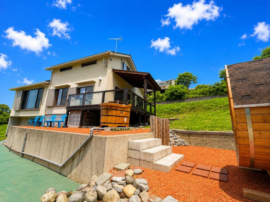 a house sitting on top of a body of water at サウナパラダイス富山 in Minamiboso
