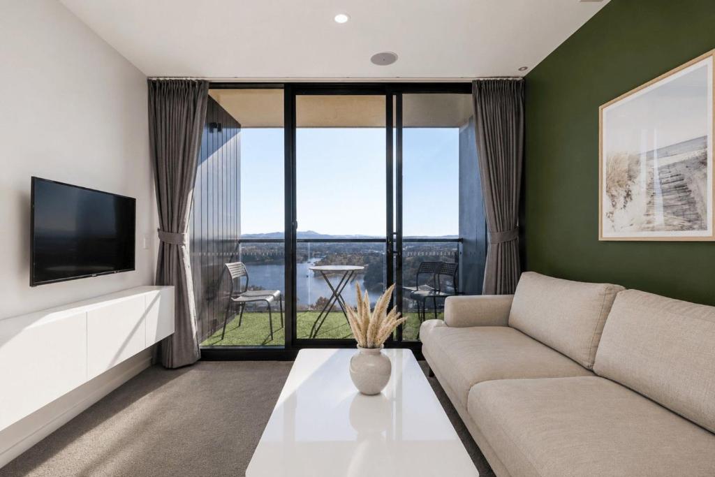 a living room with a couch and a tv at Lakeview on Grazier in Belconnen