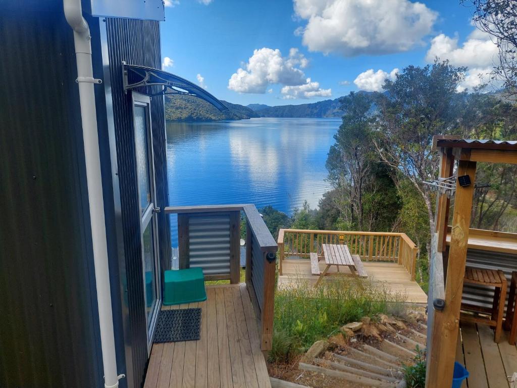 a balcony with a view of a lake at Endeavour View Eco Cabin in Endeavour Inlet