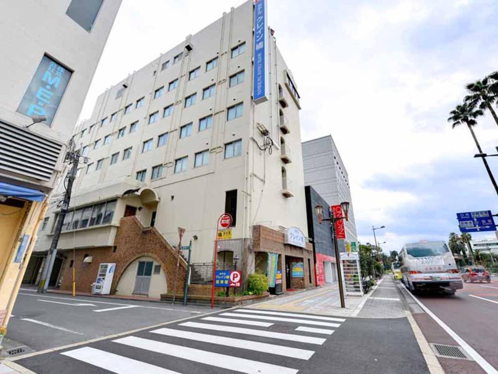 a building on a city street with a bus at Hotel Crane Tachibana in Miyazaki