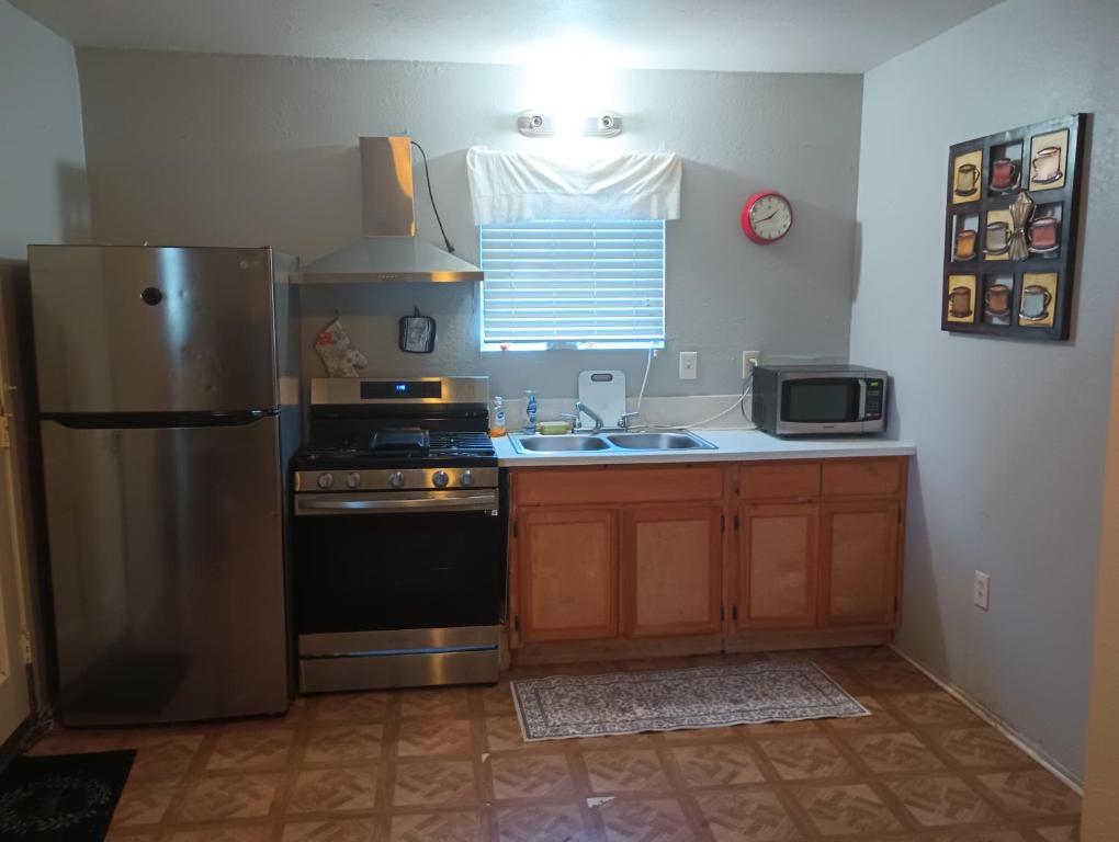 a kitchen with a stainless steel refrigerator and a sink at Nice Guest House in Artesia